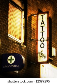 Tattoo And Piercing Sign Outside Tattoo Parlor That Is Over A Pharmacy