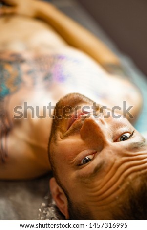 Tattoo salon process. the process of getting a tattoo on the body, a man in a tattoo parlor