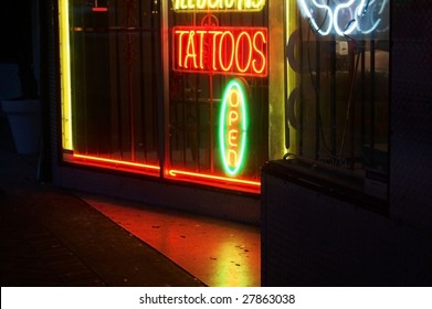 Tattoo shop sign glowing at night in the city