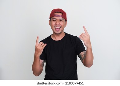 Tattooed Asian Man Wearing Plain Black Tshirt Showing Rock And Roll Pose