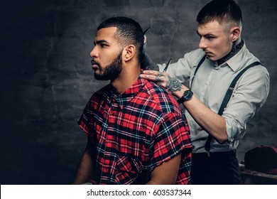 Tattooed Barber Cuts The Beard To A Black Bearded Male.