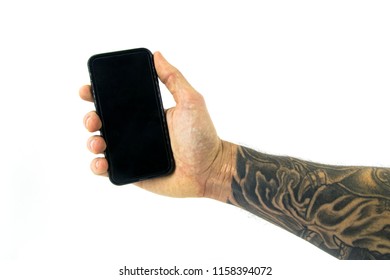 Tattooed forearm with smart phone isolated in white background