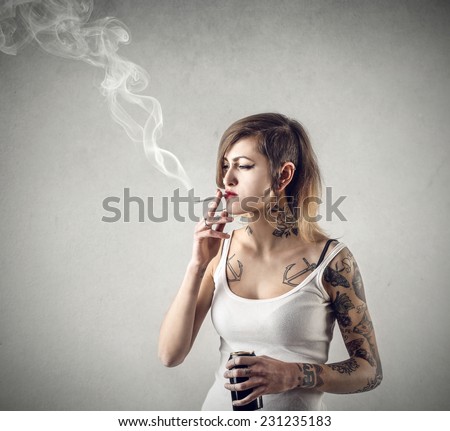 Tattooed girl smoking a cigarette 