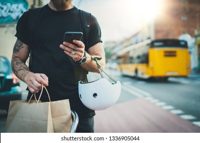 Tattooed Man Courier Using A Map App On Mobile Phone To Find The Delivery Address In The City.Courier Bicycle Delivery Food Service At Home