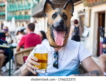 Tattooed Man With Dog Mask Drinks Beer
