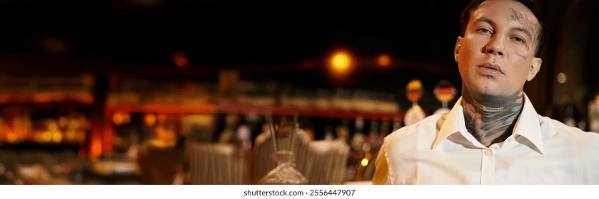 A tattooed young man relaxes in a vibrant bar, surrounded by nightlife energy and dim lights. - Powered by Shutterstock