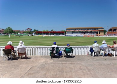 Taunton England.  The County Cricket Ground With Spectators Watching A Game In Progress. View Of Cricket Pitch And The Sir Ian Botham Grandstand. Sunny With Blue Sky.