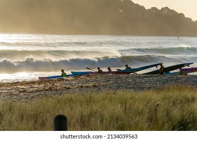 Tauranga New Zealand - March 5 2022; Lifesaving Club Members In Silhouette Preparing For A Paddle In Surf With Paddle-boards On Beach.