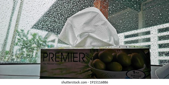 Tawau, Malaysia 12 February 2021: A Tissue Box In The Car Against The Raindrops On The Windshield Of The Car On Rainy Seasons With Blur Effect. Selective Image