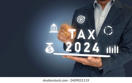 TAX 2024 and icons of money, bank, target, and graph on virtual screen. Business Man tapping on the screen having tablet.