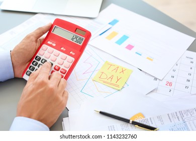 Tax accountant working with calculator at table