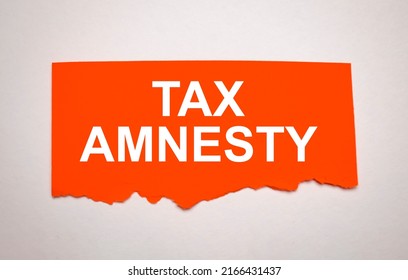 Tax Amnesty Word Written Under Torn Paper.