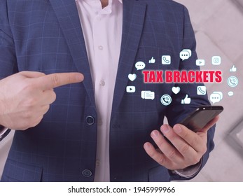  TAX BRACKETS Phrase On The Screen. Broker Use Cell Technologies At Office. Tax BracketsÂ show You TheÂ taxÂ rate You Will Pay On Each Portion Of Your Income.
