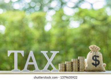 Tax Collection, Investment And Capital Gain Tax Concept : Word Tax, Rows Of Rising Coins, US Dollar Bag On A Table, Depicts A Mandatory Financial Charge Or Levy Imposed Upon A Taxpayer Or Individual