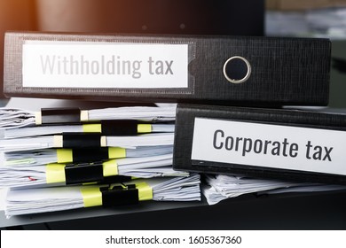 Tax concept, Withholding taxes binders files on document report in business office. Retention taxes is income tax to be paid to government by payer of income rather than by recipient of the income. - Shutterstock ID 1605367360