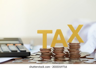 Tax Concept.Word tax put on coins and paper bill with coins on desks. - Shutterstock ID 2033319716