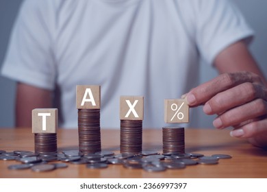 Tax Concept.Word tax and stacked coins put on desks,Tax payment and tax deduction planning. - Shutterstock ID 2366997397