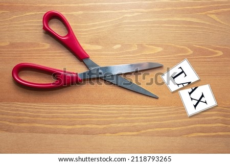 Tax cut sign with scissors and a note with tax text written on it. Tax deduction icon or symbol