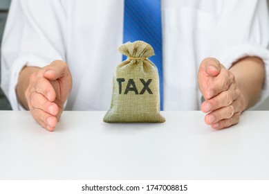 Tax equalization and protection, financial concept : Assignee protects a tax bag, depicting difference between actual tax and hypotax that employer will pay or reimburse the employee for excess tax - Shutterstock ID 1747008815
