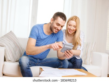 Tax, Finances, Family, Home And Happiness Concept - Smiling Couple With Papers And Calculator At Home