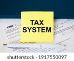 Tax form 1065 with yellow sticker with text Tax System. Notepad and white pen. Financial concept