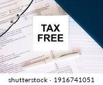 Tax form with business card with text Tax Free. Notepad, eyeglasses and white pen. Financial concept