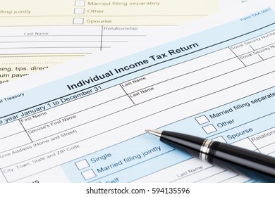 Tax form with pen; document are mock-up - Shutterstock ID 594135596