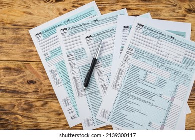 Tax Forms 1040 With A Pen On A Wooden Table. View From Above. Financial Document.