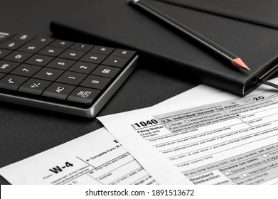 Tax forms with calculator and notepad on the office workplace. - Shutterstock ID 1891513672