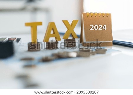 Tax golden wooden text and the number 2024 on the calendar. Pay tax in 2024 years. The new year 2024 tax concept.