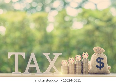 Tax on savings interest / deposit tax refund, financial concept : Piggybanks on stacks of coins and US dollar bag, depict planning for personal allowance / earning tax-free or exempt from paying tax