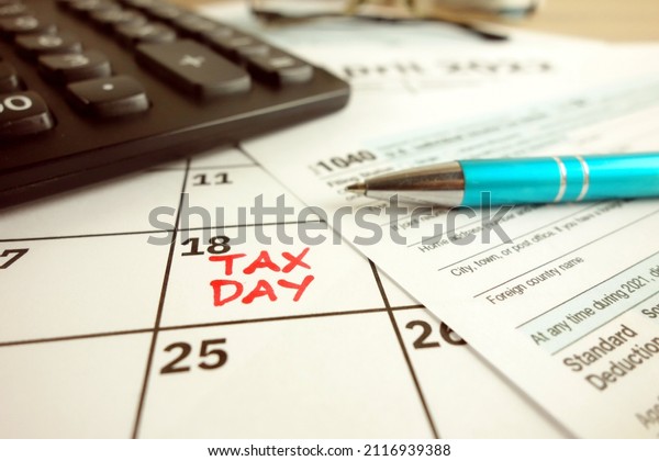 Tax payment day marked on a calendar -\
April 18, 2022 with 1040 form, financial\
concept
