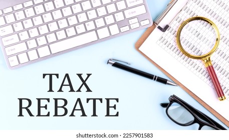 TAX REBATE text on a blue background with keyboard and clipboard, business concept - Shutterstock ID 2257901583