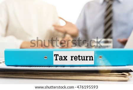 Tax return document folder on desk in meeting room with irs auditor team are audit and discuss tax refund.