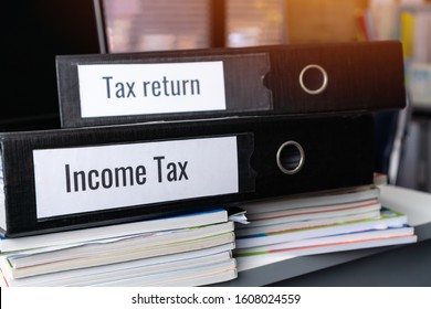 Tax return and Income tax files binder of report, document in office. completion of documentation that calculates entity’s income earned  of payable to government, organisations or potential taxpayers - Shutterstock ID 1608024559