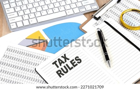 TAX RULES text on paper on chart background