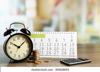 Tax time and alarm clock with coins, calculator and calendar