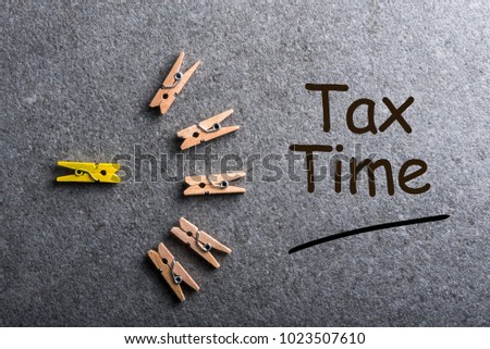 Tax Time - little wooden pins with notification of the need to file tax returns, tax form