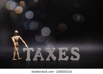 Tax time - Notification of the need to file tax returns, tax form at accauntant workplace with empty space for text, mockup or template. Word taxes dark background and man figure.