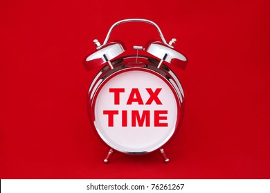 Tax Time On The Alarm Clock Face. Isolated On Red