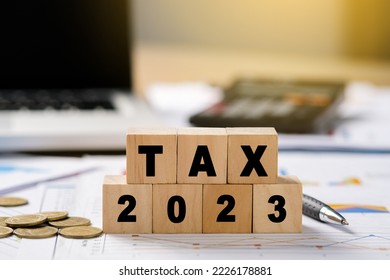 Tax time words on wooden blocks, Clipboard with tax form, money, calculator and pen on the table. Tax-filling concept. Office workplace. - Shutterstock ID 2226178881