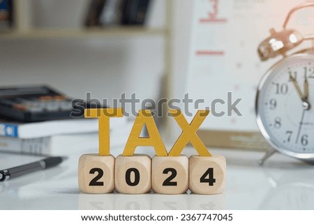 Tax and Vat 2024 Concept.Tax wooden letters on wooden cubes with 2024 on coins. income tax online return form for payment. Expenses, account, VAT, pay tax in 2024 year.