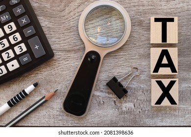 TAX. Wooden Cubes On A Wooden Background. Three Wood Blocks