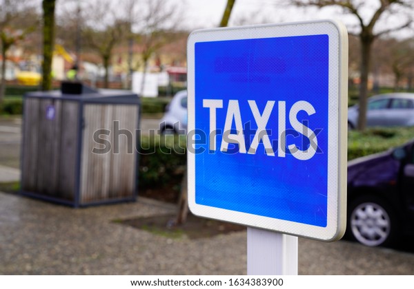 taxi\
blue sign service signage hanging on pole\
street