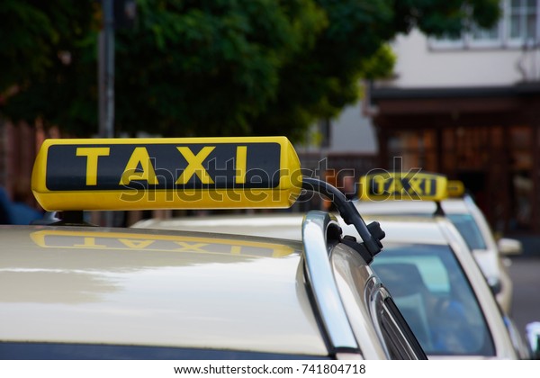 Taxi cab cars in a\
row in the city of Mainz