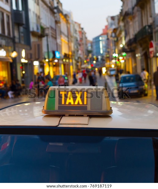 Taxi cab on\
an Old Town street of Porto,\
Portugal