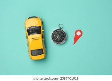 Taxi Car model with geolocation point sign and compass on blue background. Navigation. Flat lay - Powered by Shutterstock