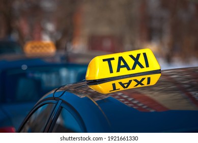 Taxi Car Sign At Day Time, Taxi Sign On Cab Roof While Parking On Road Waiting For Passaenger. Taxi Rank. Taking Safe Rideshare During Coronavirus. Luminous Taxi Top Sign