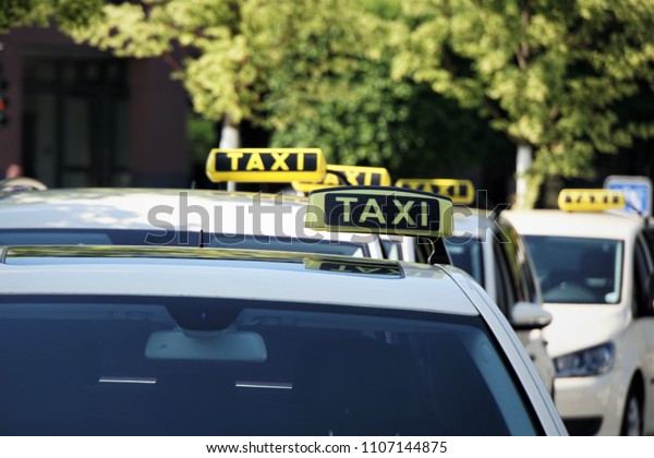 Taxi cars on the city street in Germany. Detail of\
yellow taxi car.