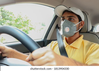 A Taxi Driver In KN95 Mask, Protection During COVID 19 Or Coronavirus Disease Pandemic. A Man Driving Car Puts On A Medical Mask For Protection From Virus Infection Disease. Copy Space.